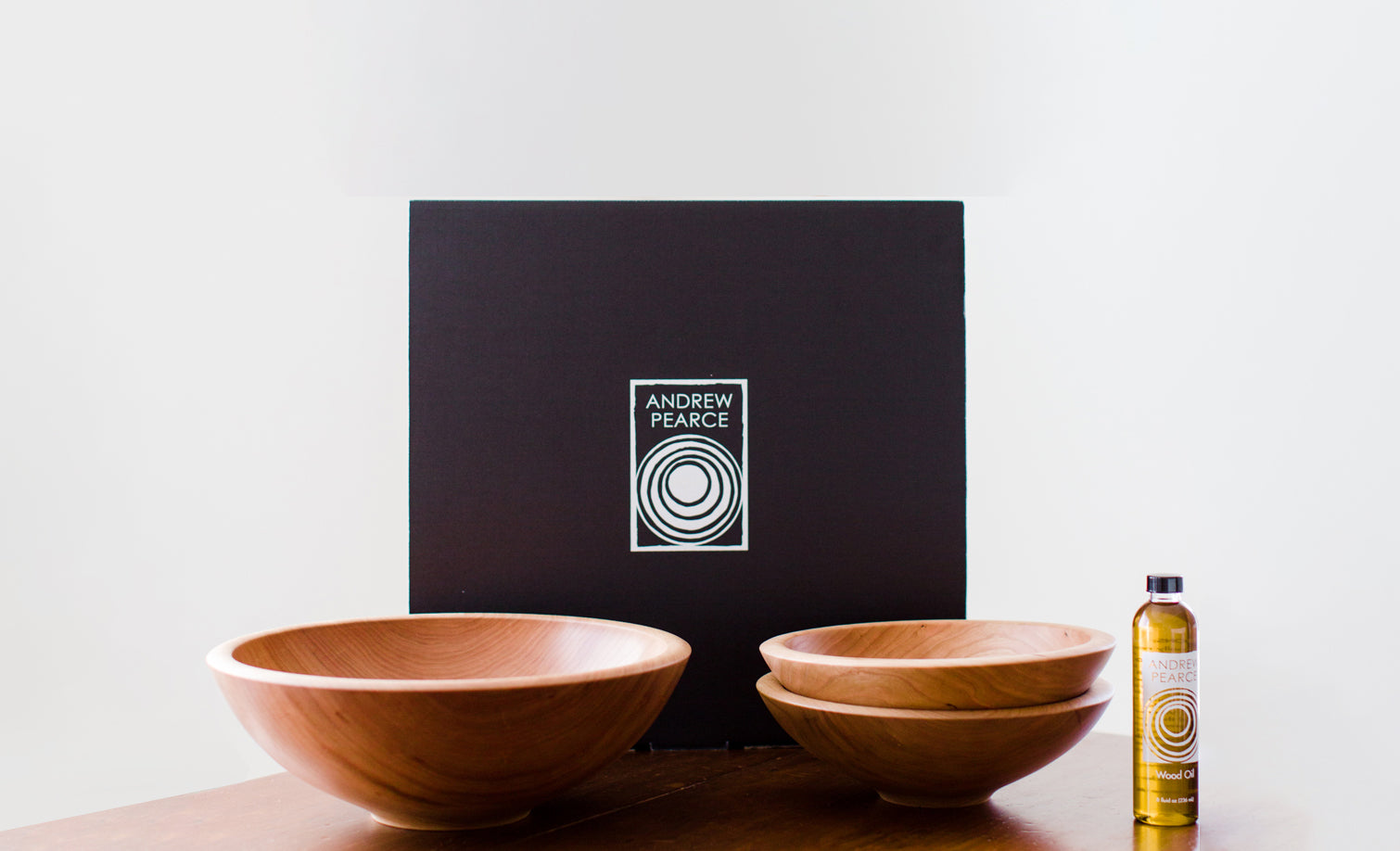 Large wood bowl with two small wood salad bowls shown with food safe wood oil and an Andrew Pearce Bowls Gift Box