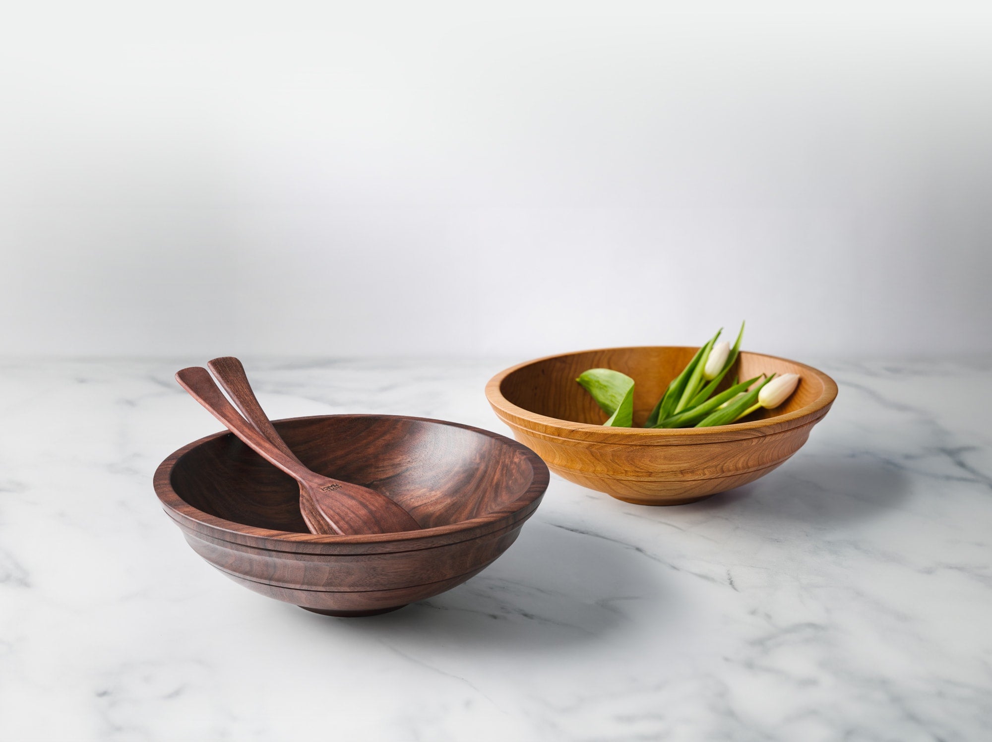 Wooden Bowls from Andrew Pearce Bowls in Hartland Vermont shown in walnut and cherry with wooden salad servers and fresh cut flowers