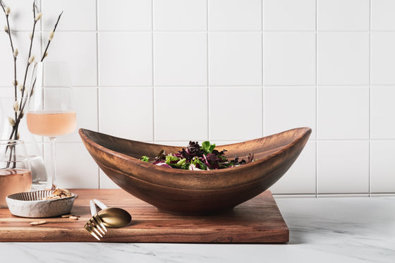 live edge wooden salad bowl shown in walnut with fresh greens