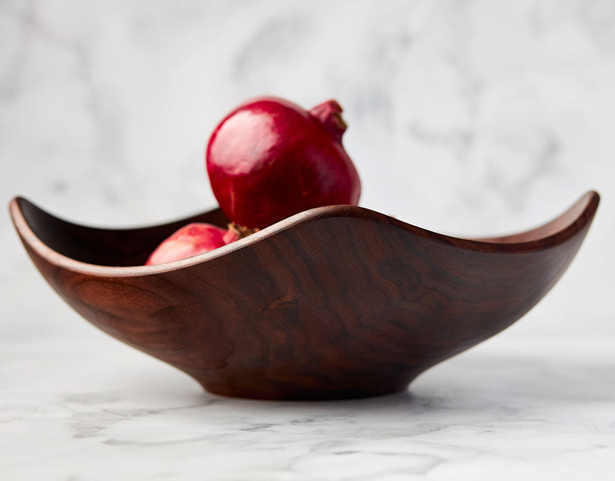 Square wooden bowl shown with pomegranates 