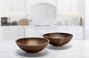 wooden bowls in black walnut shown two in a white kitchen