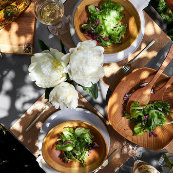 Outdoor table set with wood bowls and salad